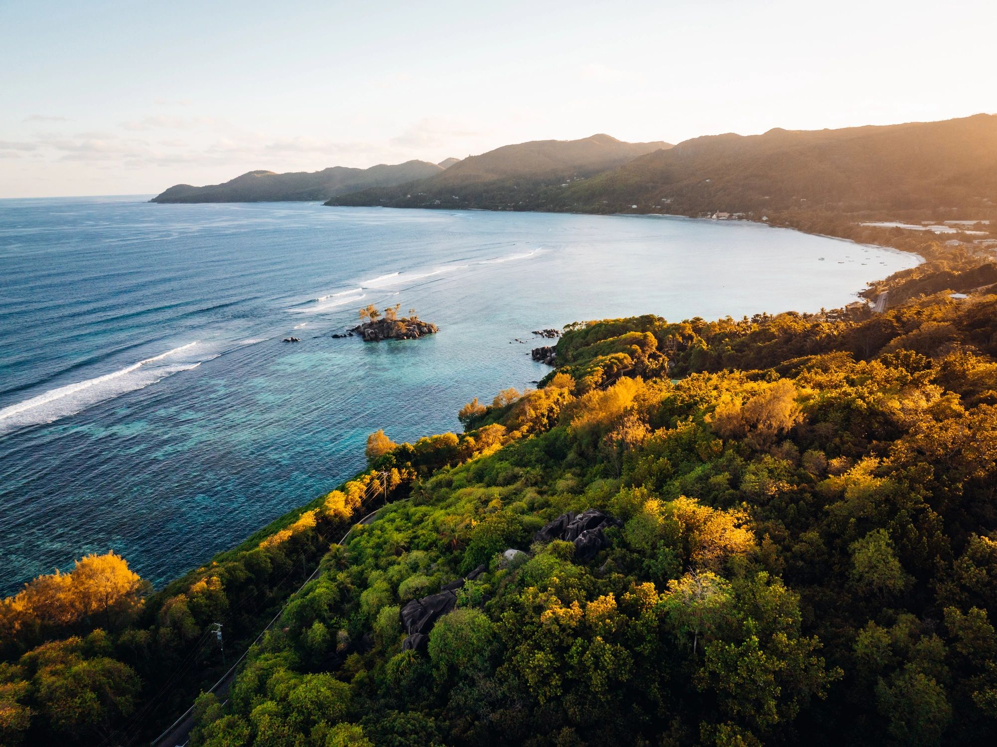 Grounding ocean coastline with lush green hills and calm blue water